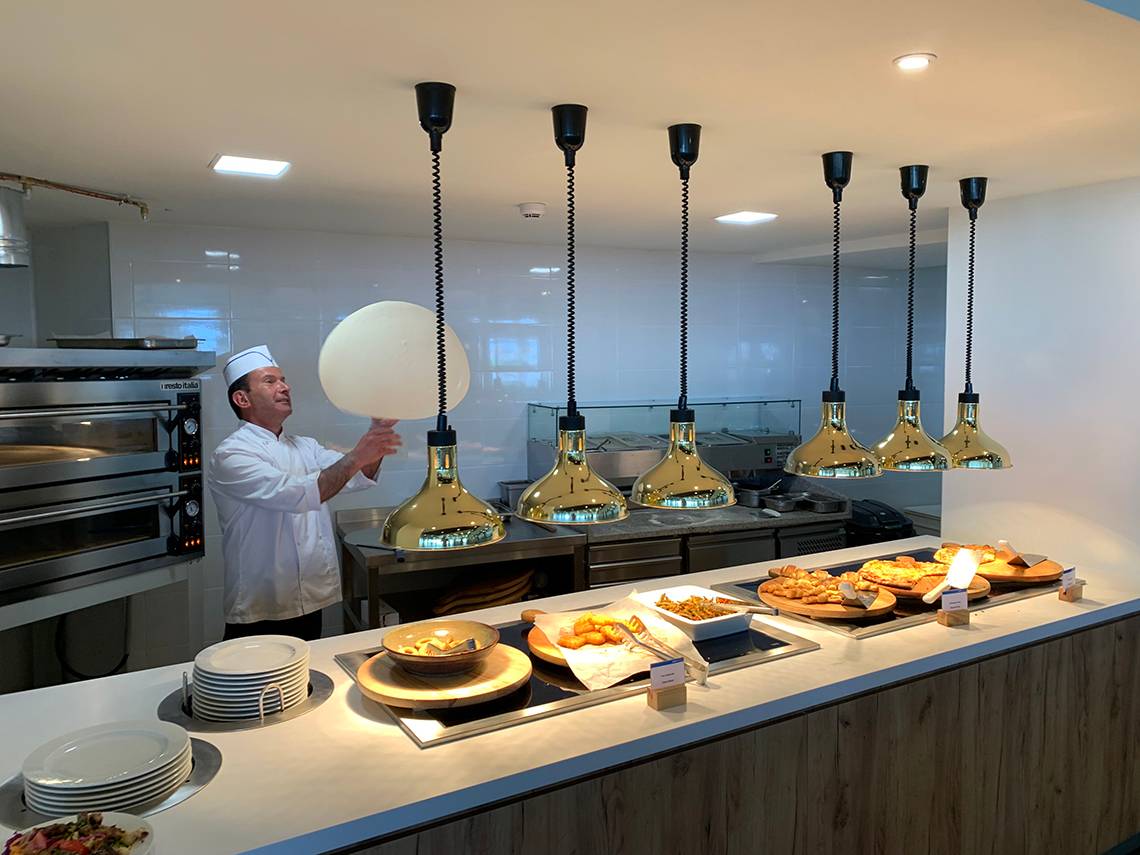 Buffet-Tisch mit verschiedenen Speisen und goldenen Lampen im Hotel Creta Princess Aquapark & Spa.