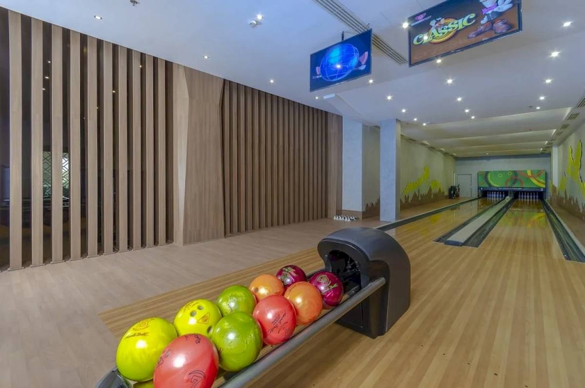 Ein Bowlingbahn im Titanic Royal Hotel mit Bowlingkugeln und Monitoren an der Decke.