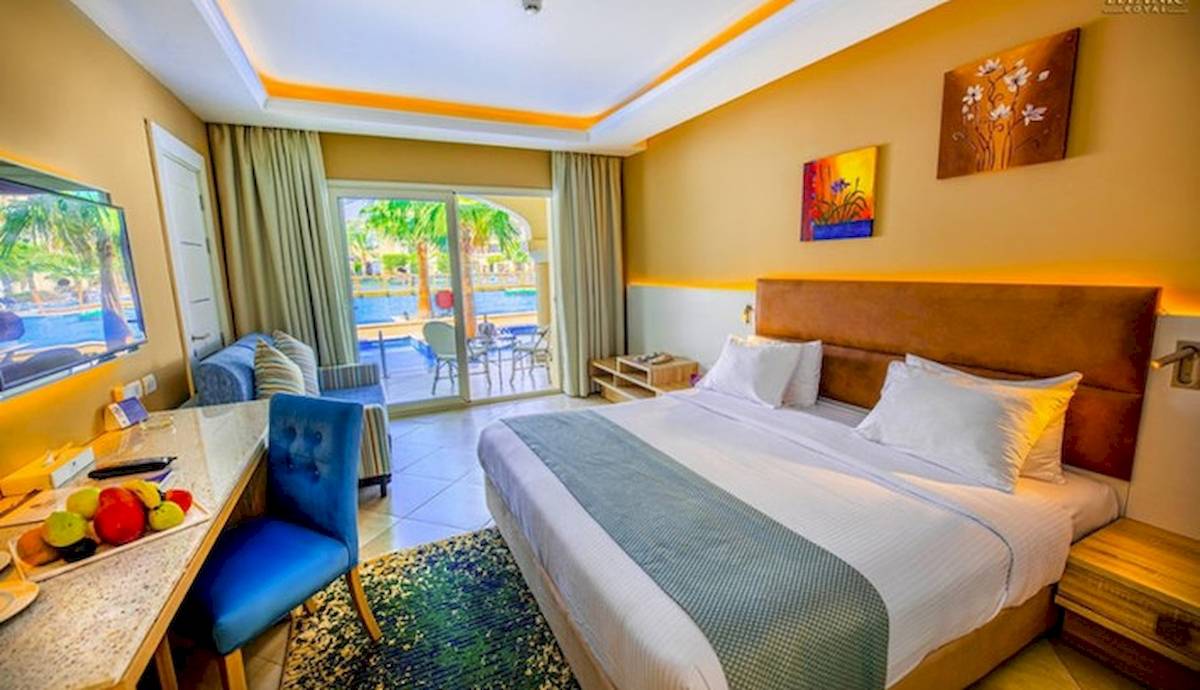 Innenansicht eines Zimmers im Titanic Royal Hotel mit Bett, Schreibtisch und Balkon.