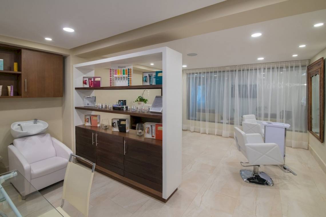 Innenansicht des Friseursalons im Emotions By Hodelpa Hotel in Puerto Plata, mit modernen Möbeln und heller Beleuchtung.