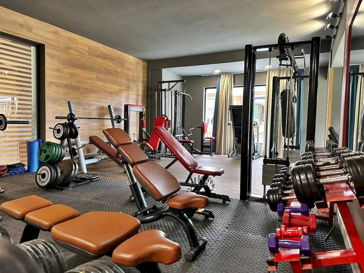 Fitness-Center im Sandy Beach Resort mit verschiedenen Trainingsgeräten und Gewichten.