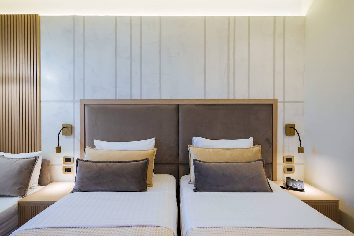 Doppelbett im Gloria Palace Hotel & SPA mit modernen Möbeln und weißen Wänden.
