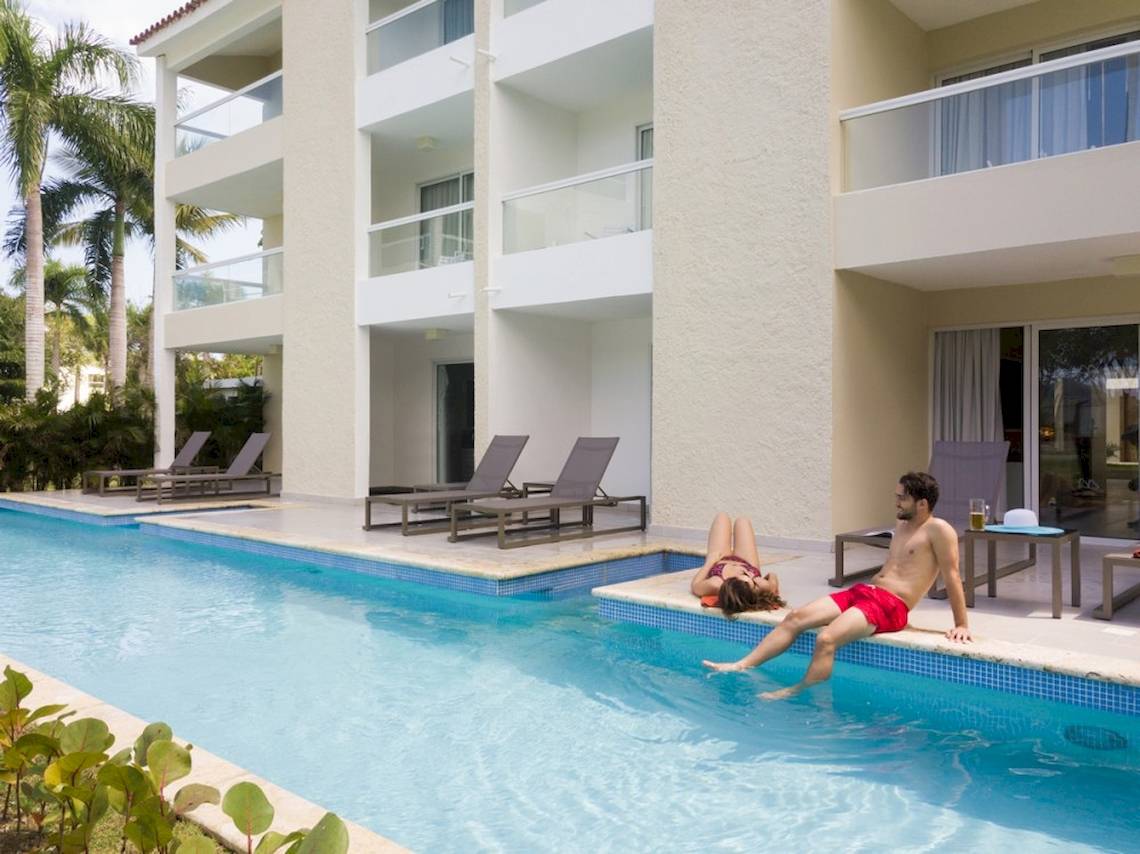 Ein Mann und eine Frau sitzen im Pool des Emotions By Hodelpa Hotels