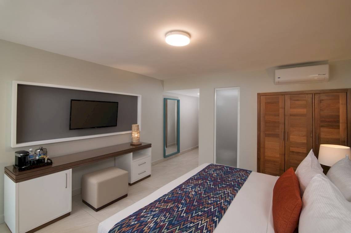 Hotelzimmer von Emotions By Hodelpa in Puerto Plata mit Bett, Fernseher und Schreibtisch.