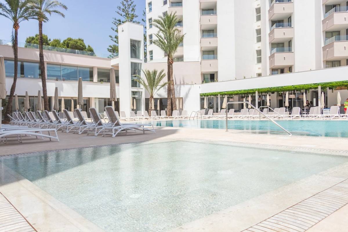 Pool-Lounge-Bereich im Hipotels Bahia Grande Hotel mit weißen Liegestühlen und Palmen