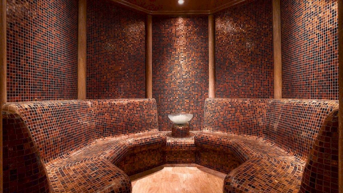 Innenansicht der Sauna im Grand Hyatt Dubai mit gefliesten Wänden und Bänken.