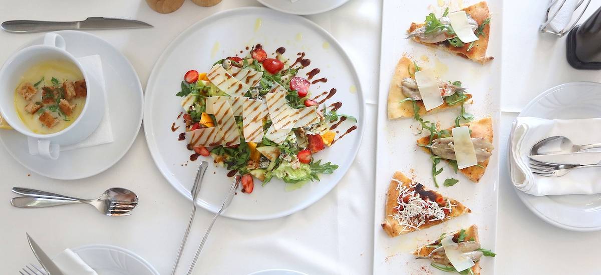 Gedeckter Tisch im Dyrrah Hotel mit Salat, Brot und Suppe.