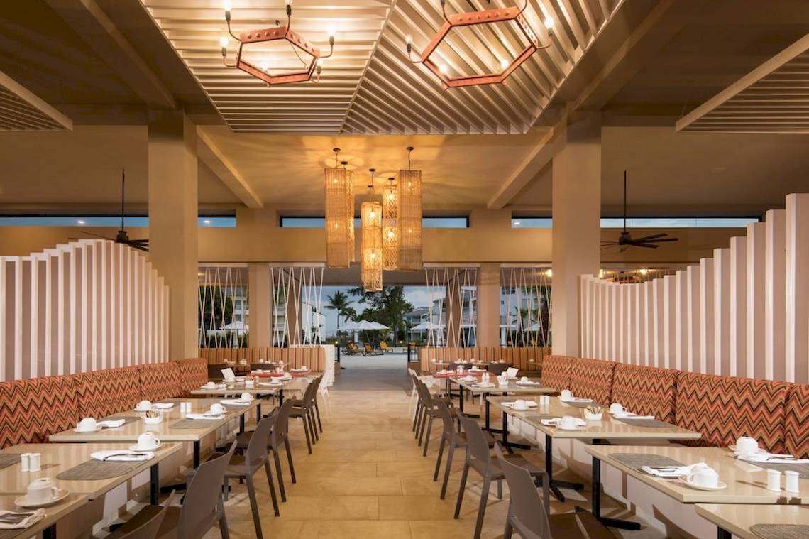 Innenansicht des Restaurants im Emotions By Hodelpa Hotel mit Tischen und Stühlen.