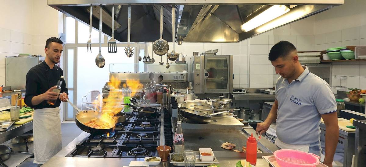 Zwei Männer kochen in der Küche des Dyrrah Hotels.