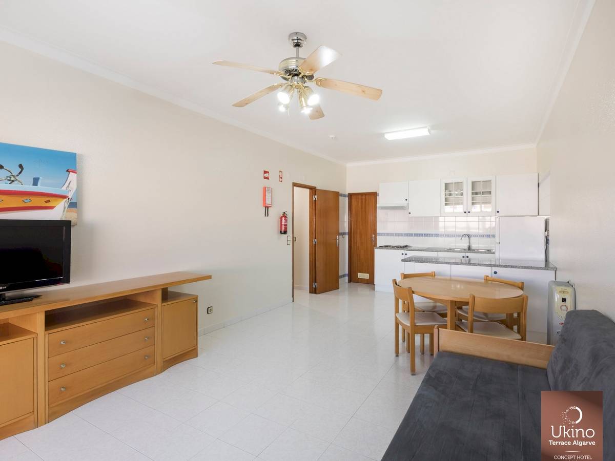 Innenbereich des Ukino Terrace Algarve Hotels mit Wohnzimmer, Küche und Esstisch.