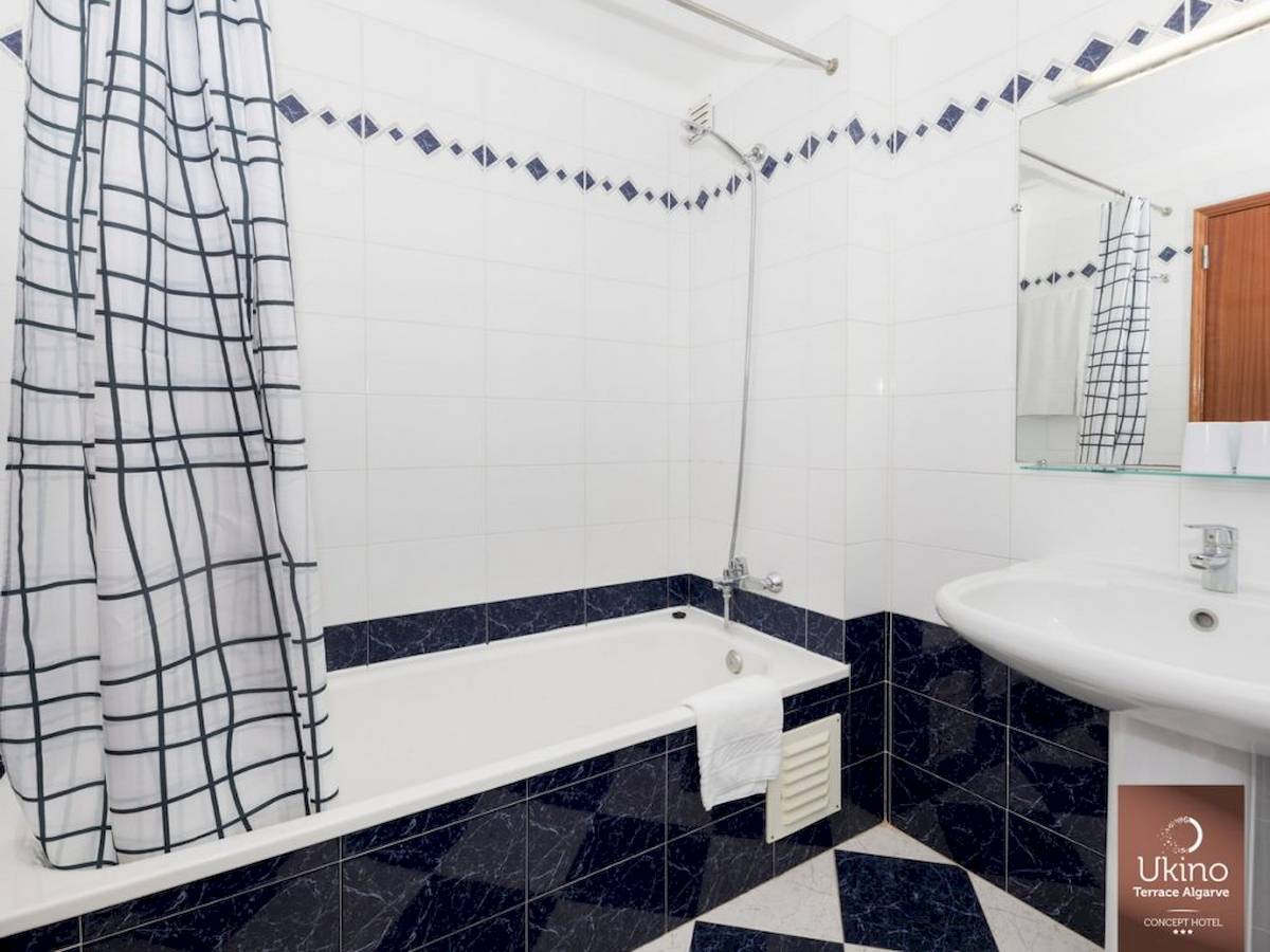 Badezimmer im Ukino Terrace Algarve Hotel mit Badewanne und Dusche