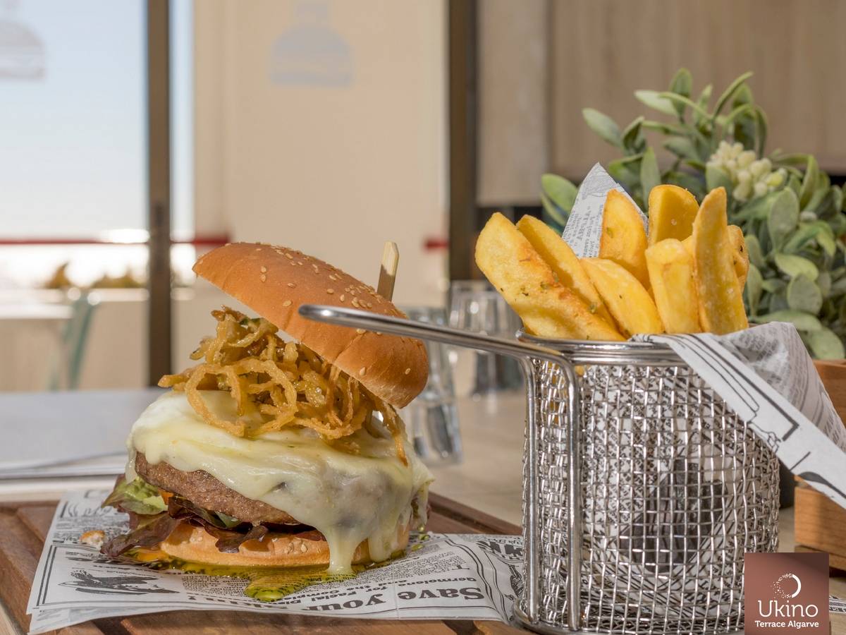 Ein Burger mit Pommes auf einem Tisch im Ukino Terrace Algarve Hotel.