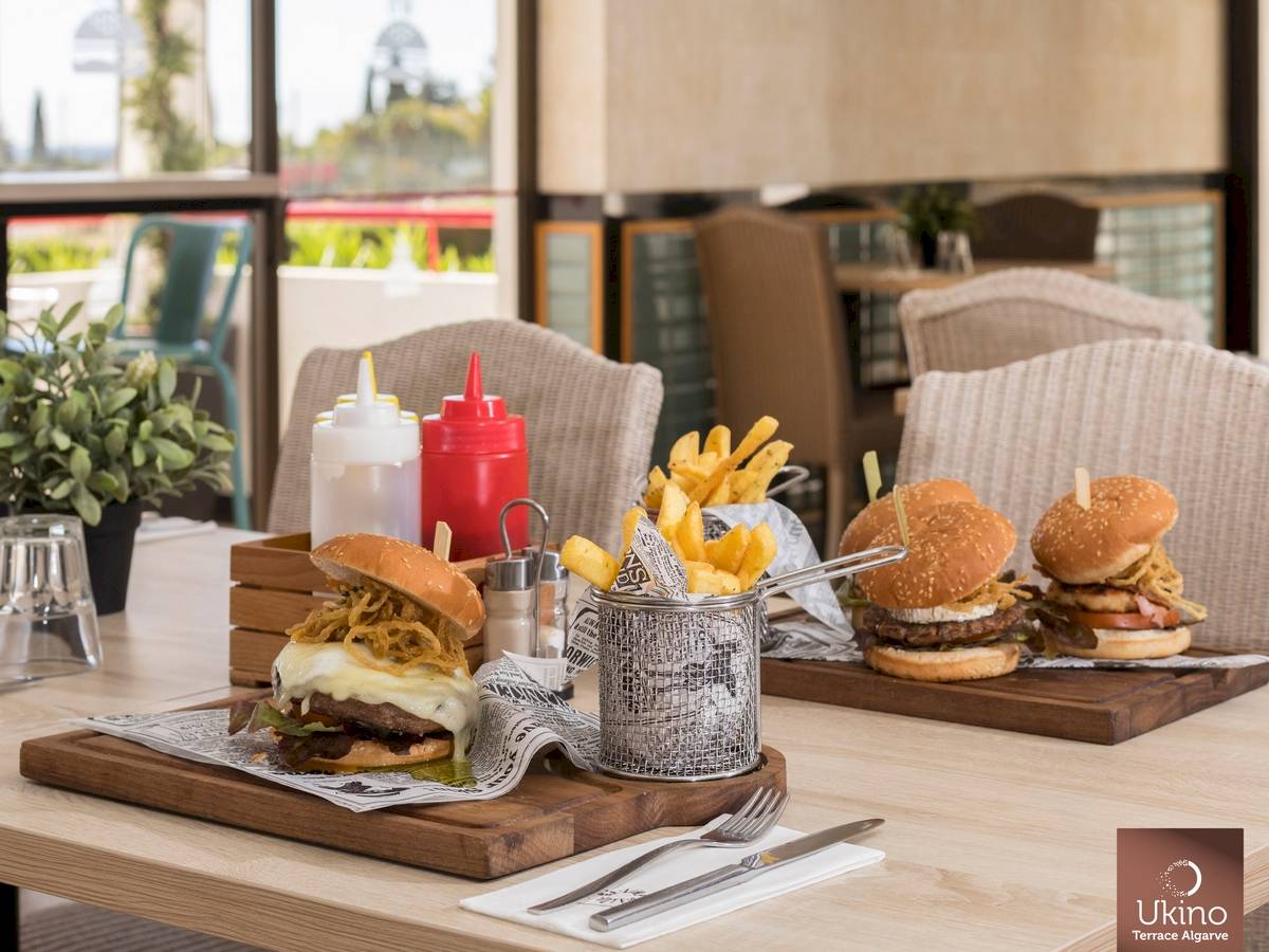 Restauranttisch im Ukino Terrace Algarve mit Burgern, Pommes und Beilagen