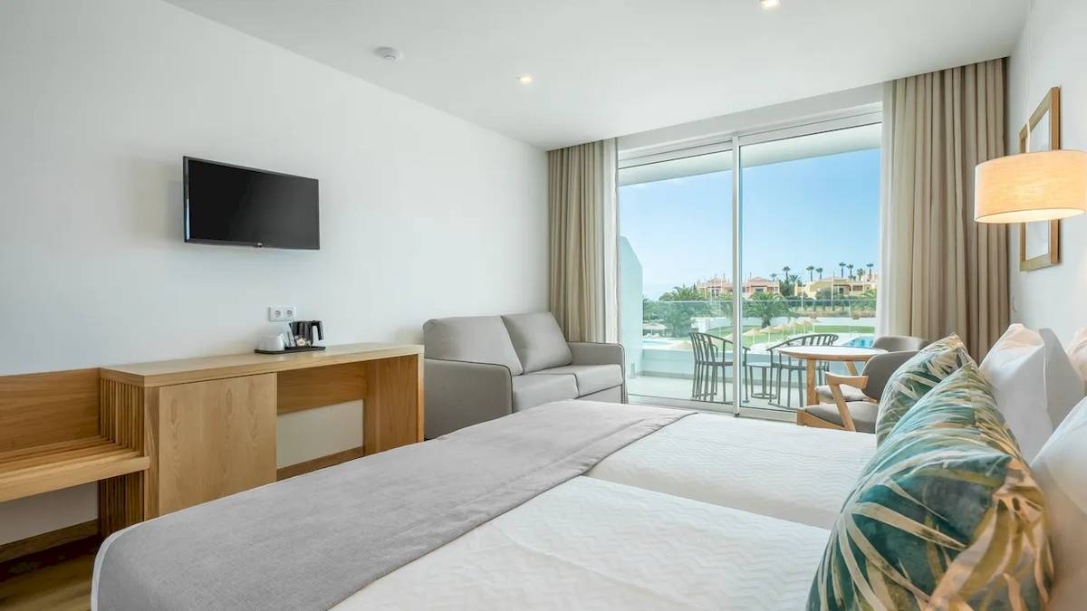 Doppelzimmer im Ancora Park Hotel mit Bett, Sofa, Fernseher und Terrassenblick.