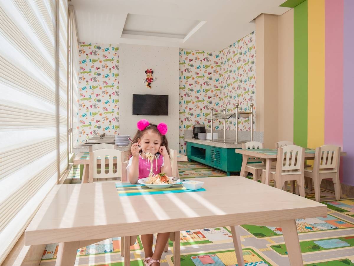 Kleines Mädchen isst Nudeln im Pickalbatros Aqua Vista Resort Kinderzimmer.