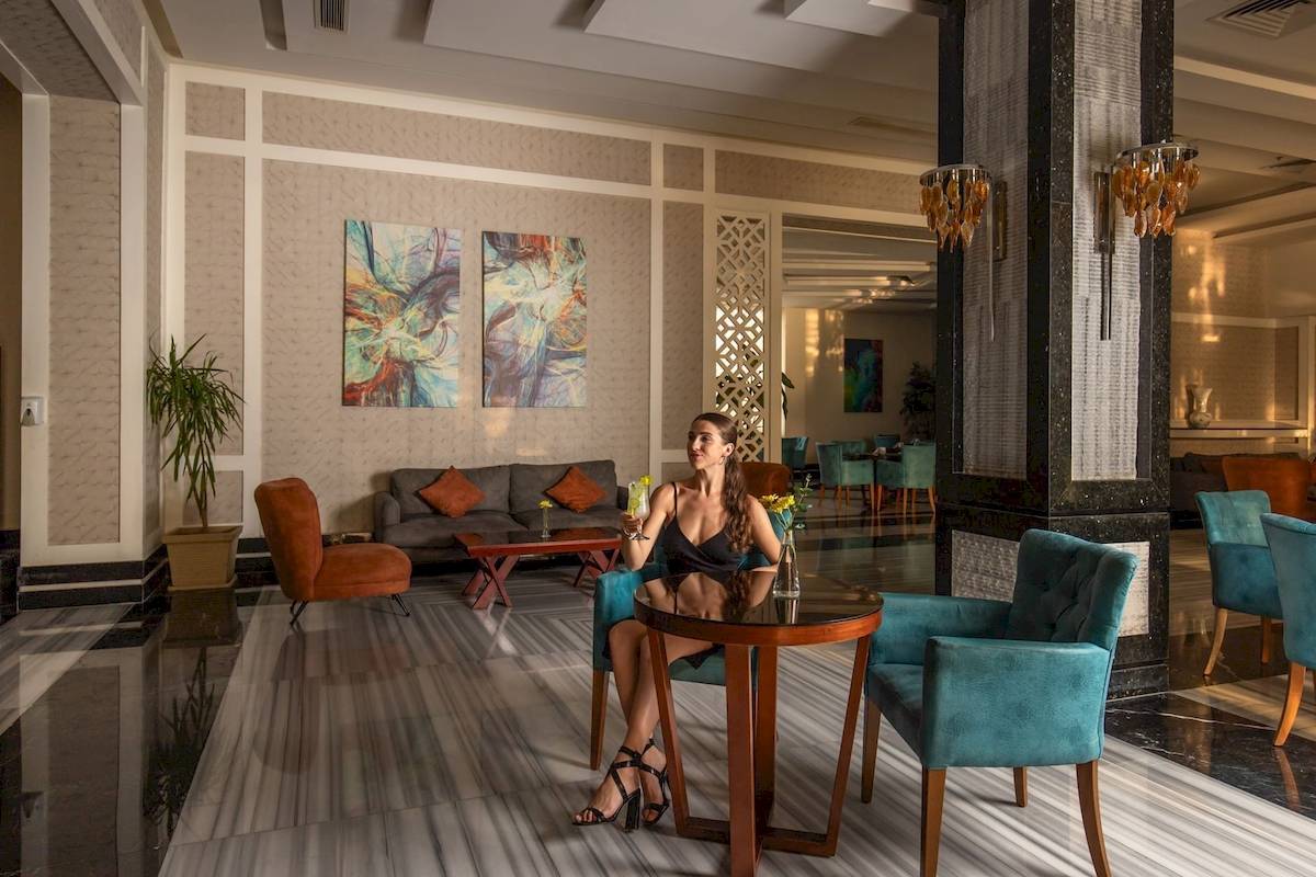 Frau sitzt an einem Tisch in der Lobby des Pickalbatros Aqua Vista Resort
