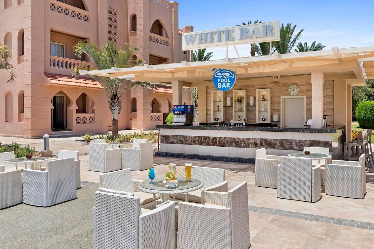 Außenbereich des Pickalbatros Aqua Vista Resorts mit einer Bar und weißen Möbeln.
