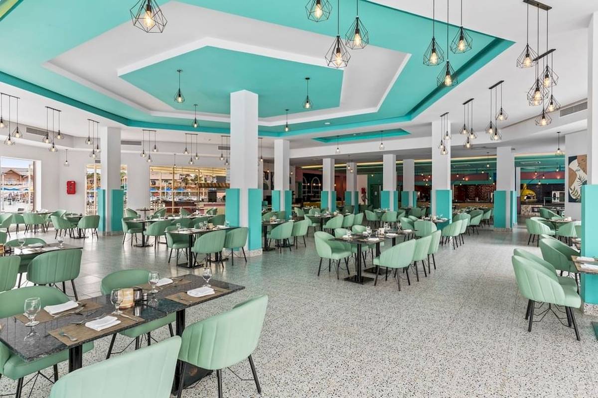 Innenraum des Restaurants im Pickalbatros Water Valley Resort by Neverland, mit blauen und weißen Wänden und grünen Stühlen.