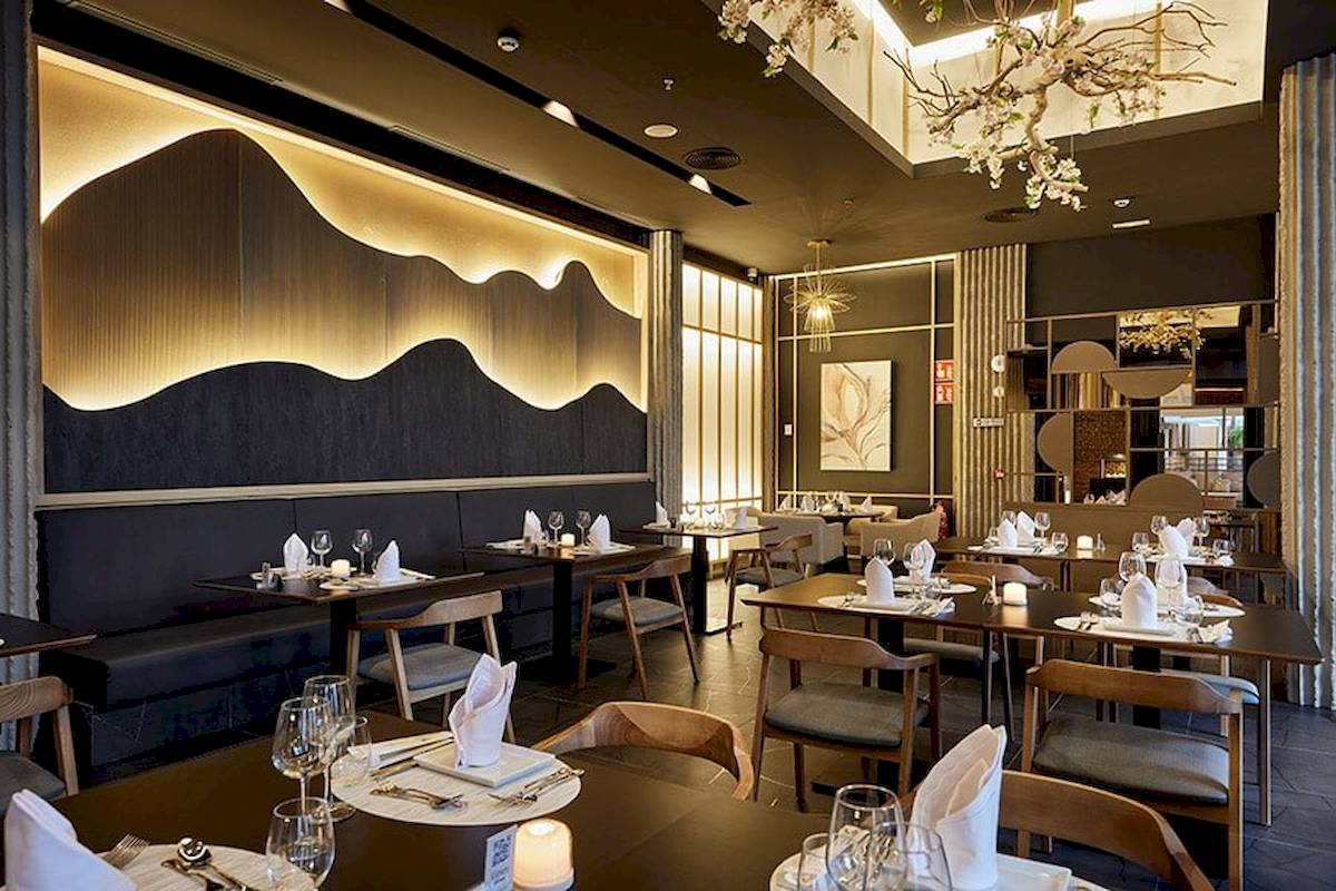 Innenansicht des Restaurants im RIU Palace Macao mit gedeckten Tischen und dekorativer Beleuchtung.