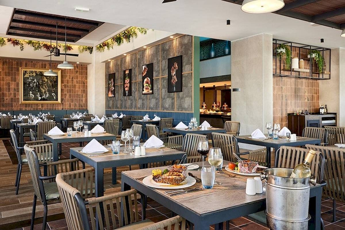 Innenansicht eines Restaurants im RIU Palace Macao mit gedeckten Tischen und Stühlen.