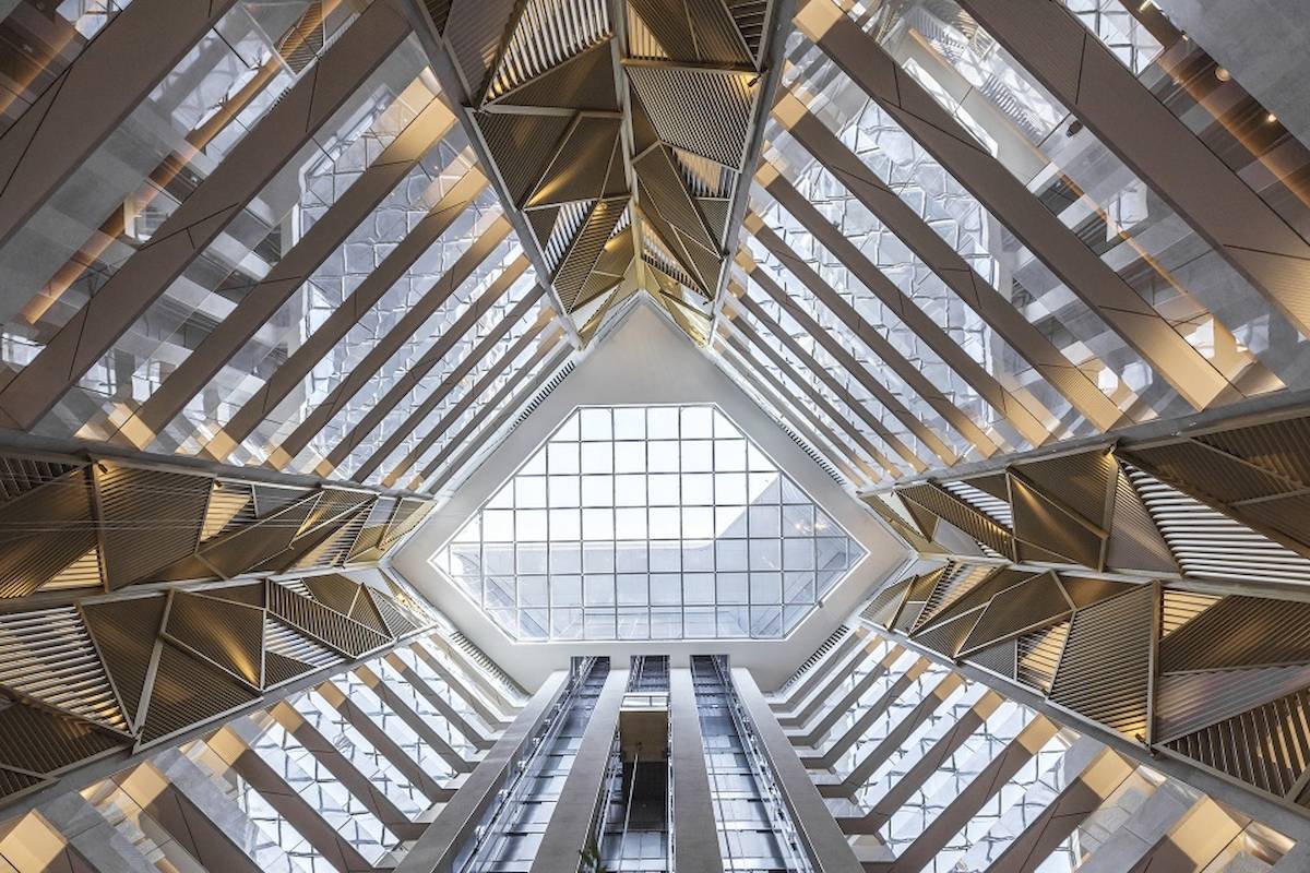 Innenansicht des Al Bandar Rotana Hotels mit Glasdach und geometrischen Mustern.