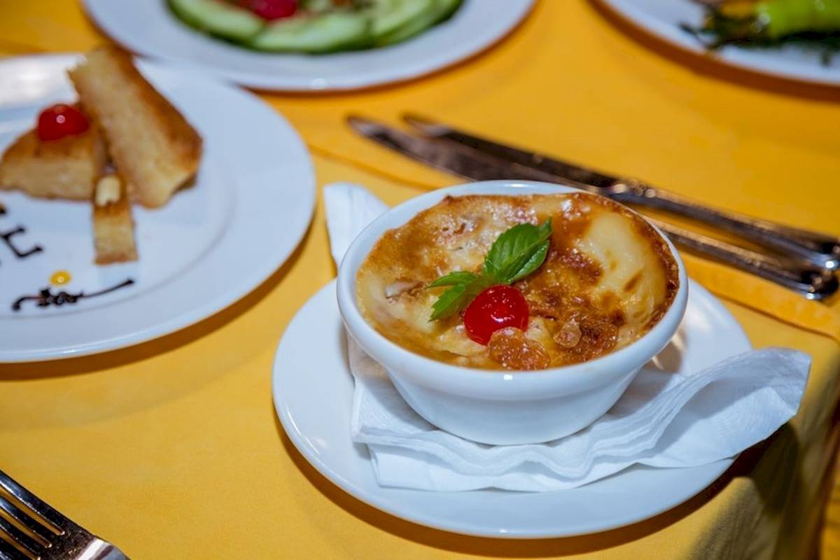 Speisen auf einem Tisch im Golden Beach Resort, einschließlich einer Suppe in einer weißen Schüssel mit einer grünen Minzblatt.