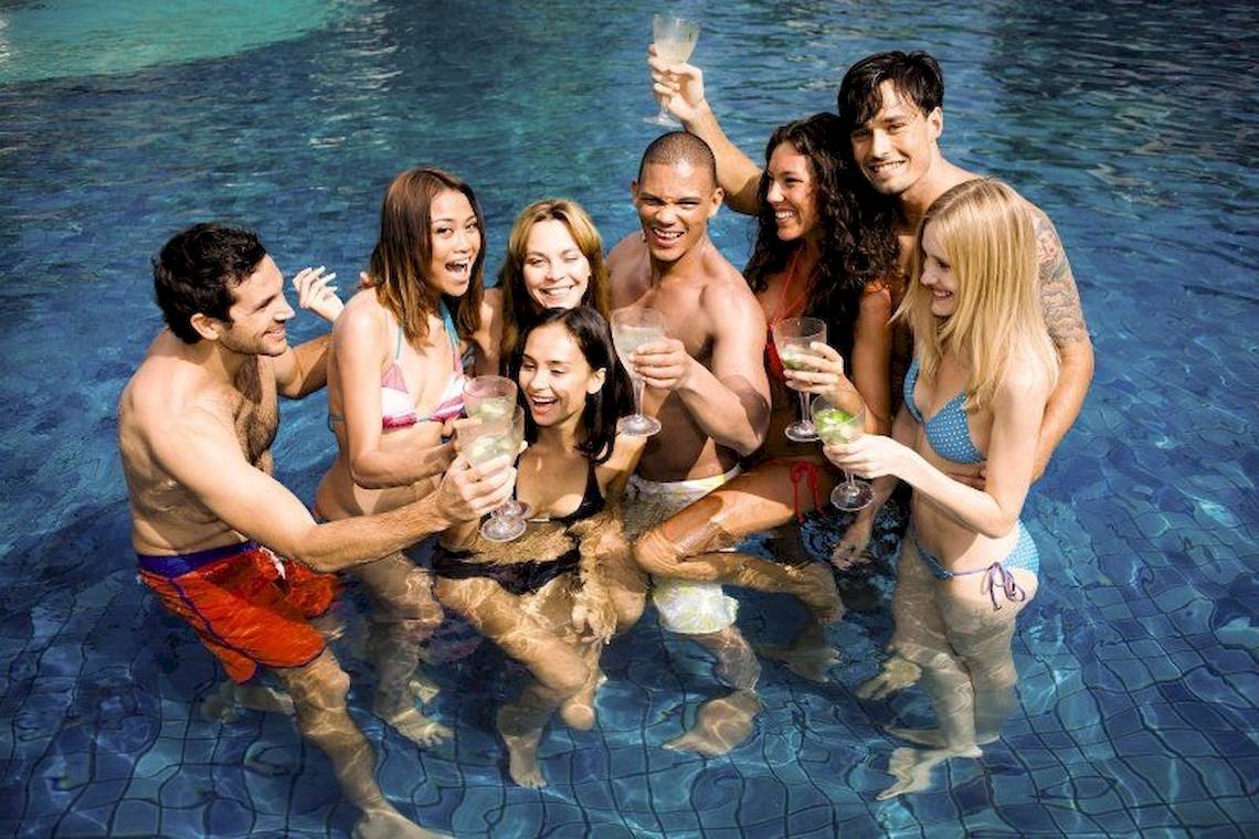 Gruppe junger Leute, die Cocktails im Pool des Hard Rock Hotels auf Ibiza genießen.