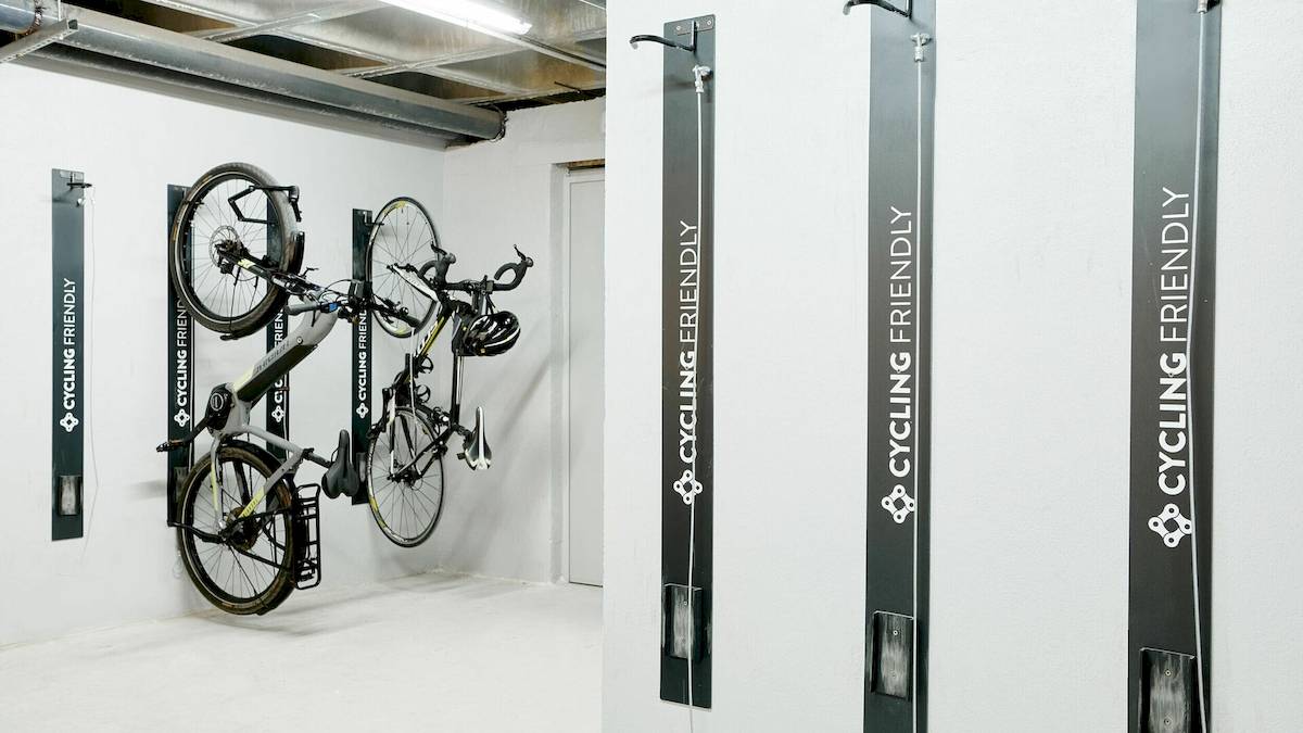 Fahrräder, die an der Wand eines Hotels aufgehängt sind, mit Schildern, die 'Cycling Friendly' und 'Cycling' bedeuten.