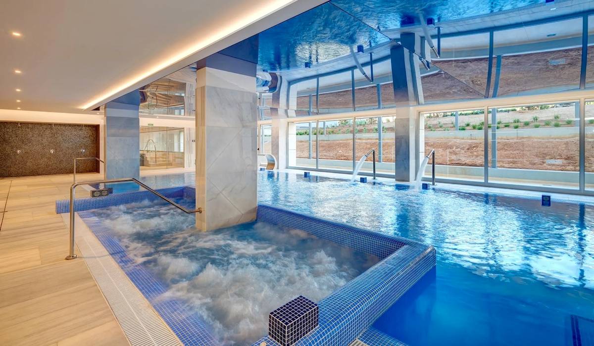 Indoor-Poolbereich des Hipotels Gran Playa de Palma mit Whirlpool und blauen Kacheln.