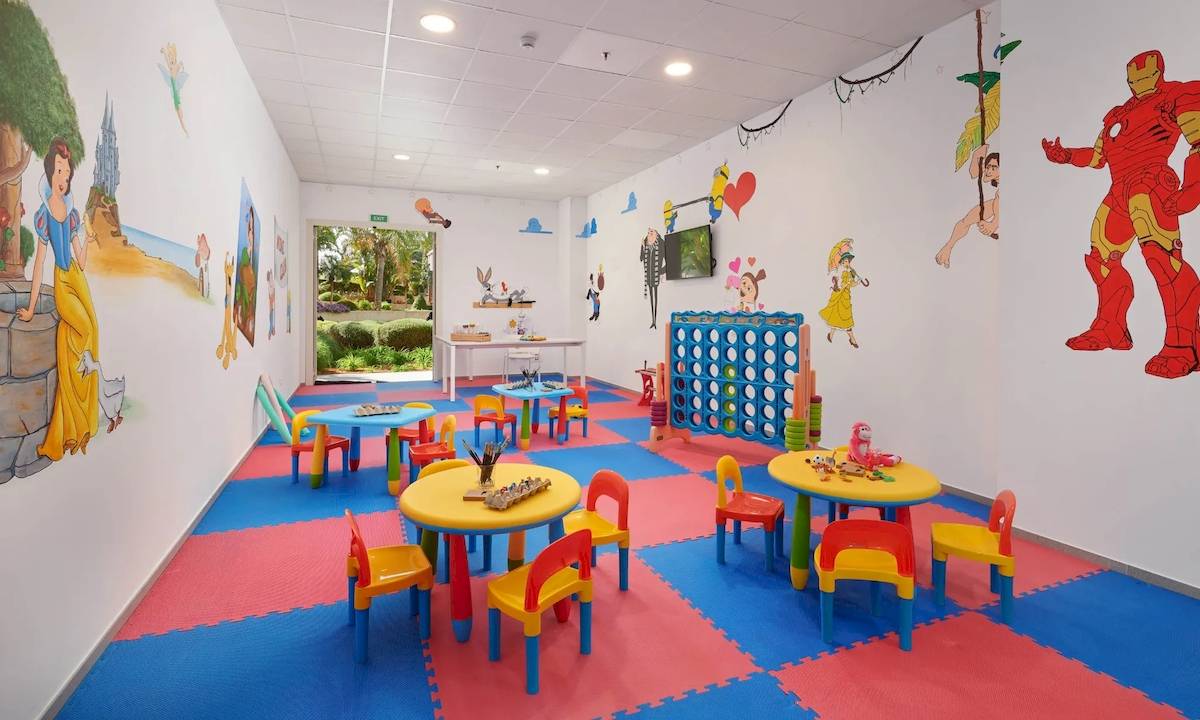 Kinderspielzimmer im Hipotels Gran Playa de Palma mit bunten Tischen, Stühlen und Wandmalereien.