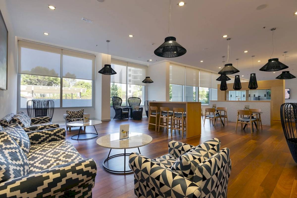 Innenbereich der Lobby im Hipotels Gran Playa de Palma mit modernen Möbeln, Holzböden und großen Fenstern.