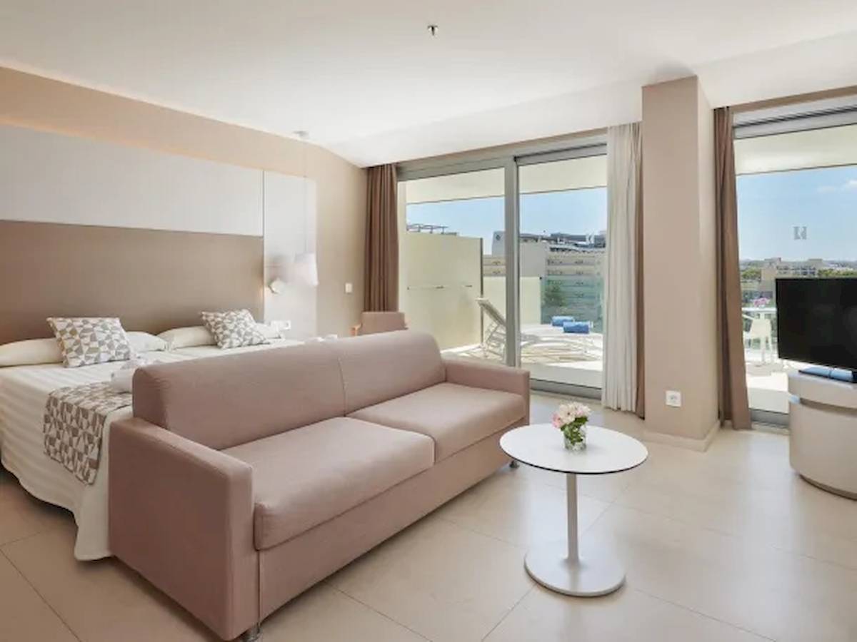 Suite Zimmer im Hipotels Gran Playa de Palma mit Bett, Sofa, Tisch und Fernseher.