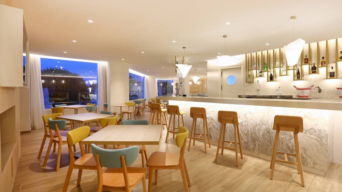 Innenbereich des Iberostar Playa de Muro Hotels mit Bar und Sitzgelegenheiten.