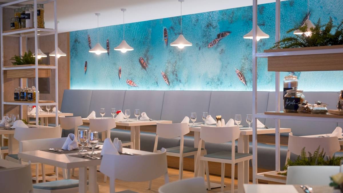 Speisesaal des Iberostar Playa de Muro Hotels mit modernem Interieur und Meerestapete.