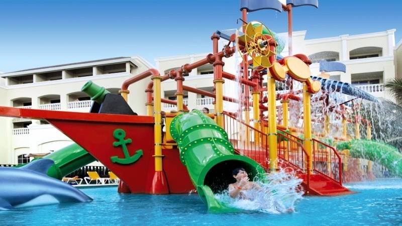 Kinderpool im Iberostar Selection Rose Hall Suites Hotel mit einem Piratenschiff und Wasserrutschen.