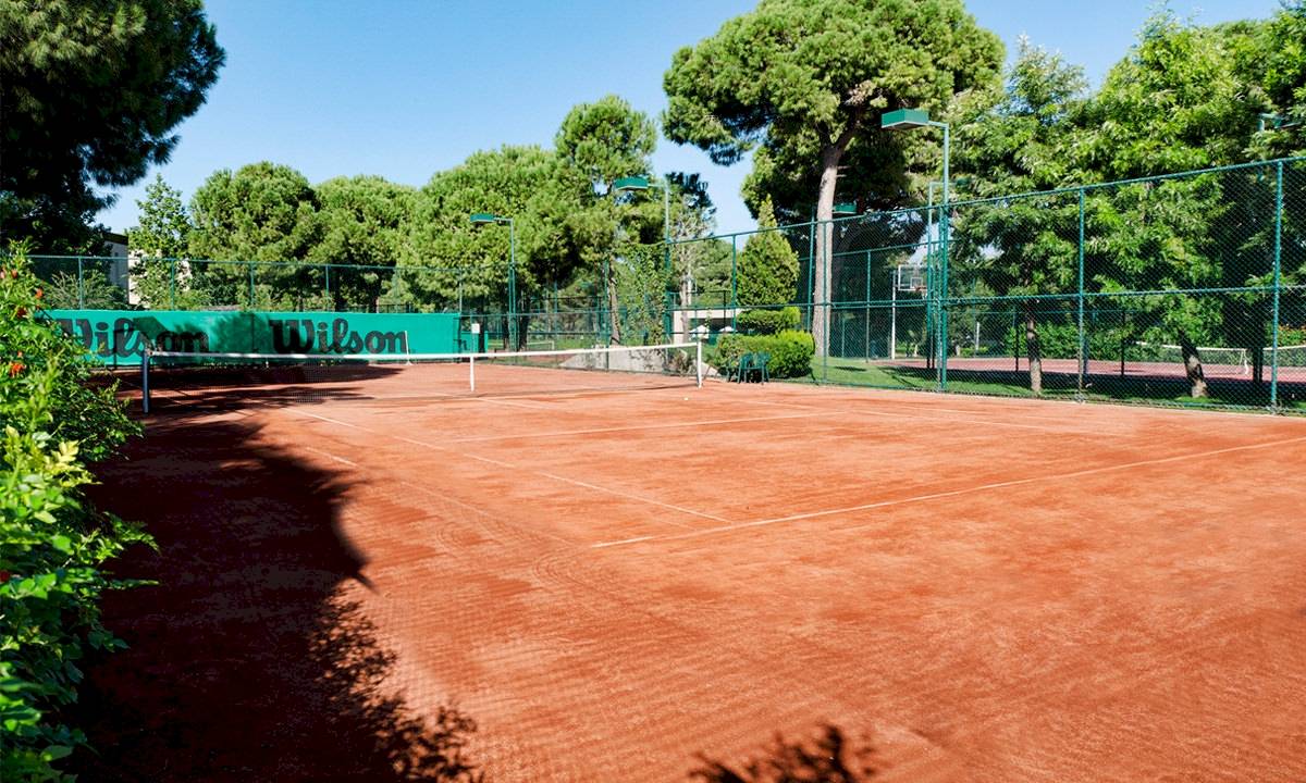 Tennisplatz im Gloria Serenity Resort mit Wilson-Werbetafeln.