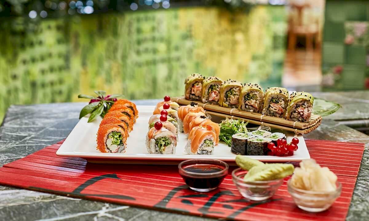 Sushi-Platte auf einem Tisch im Gloria Golf Resort mit Sojasauce und Beilagen.