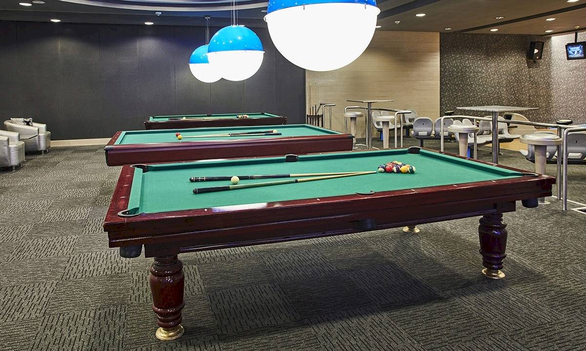 Zwei Billardtische im Gloria Golf Resort mit Ballkugeln und Stöcken.