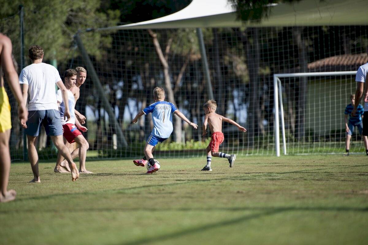 Jugendliche spielen Fussball auf dem Rasen des Xanadu Resort Hotel.