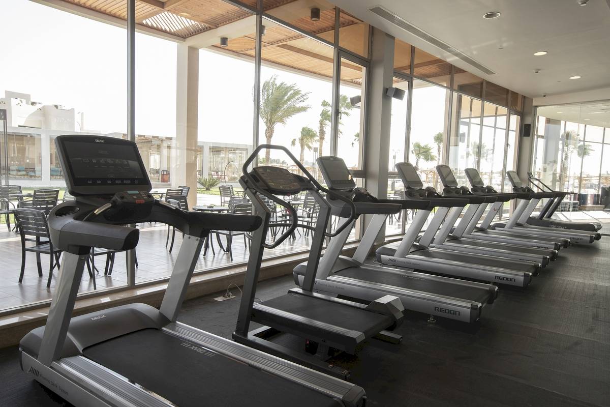 Fitnessstudio im Xanadu Makadi Bay Hotel mit einer Reihe von Laufbändern und großen Fenstern.