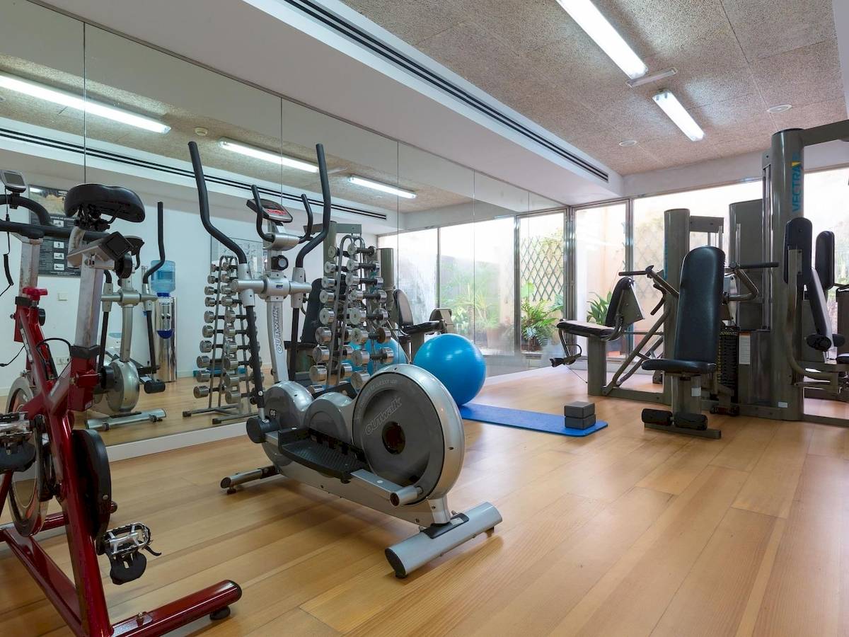 Innenansicht des Fitnesscenters des Aimia Hotels mit verschiedenen Trainingsgeräten und Geräten.