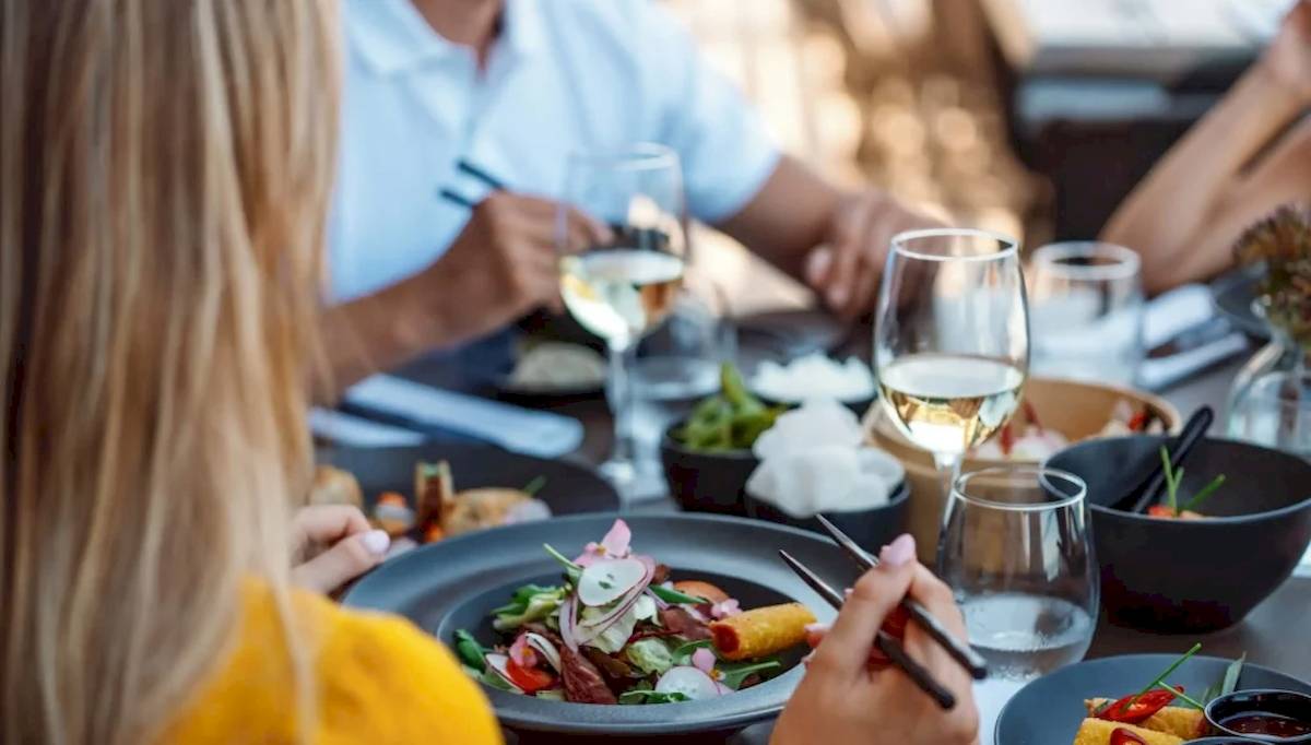 Leute essen im Restaurant mit verschiedenen Gerichten und Getränken
