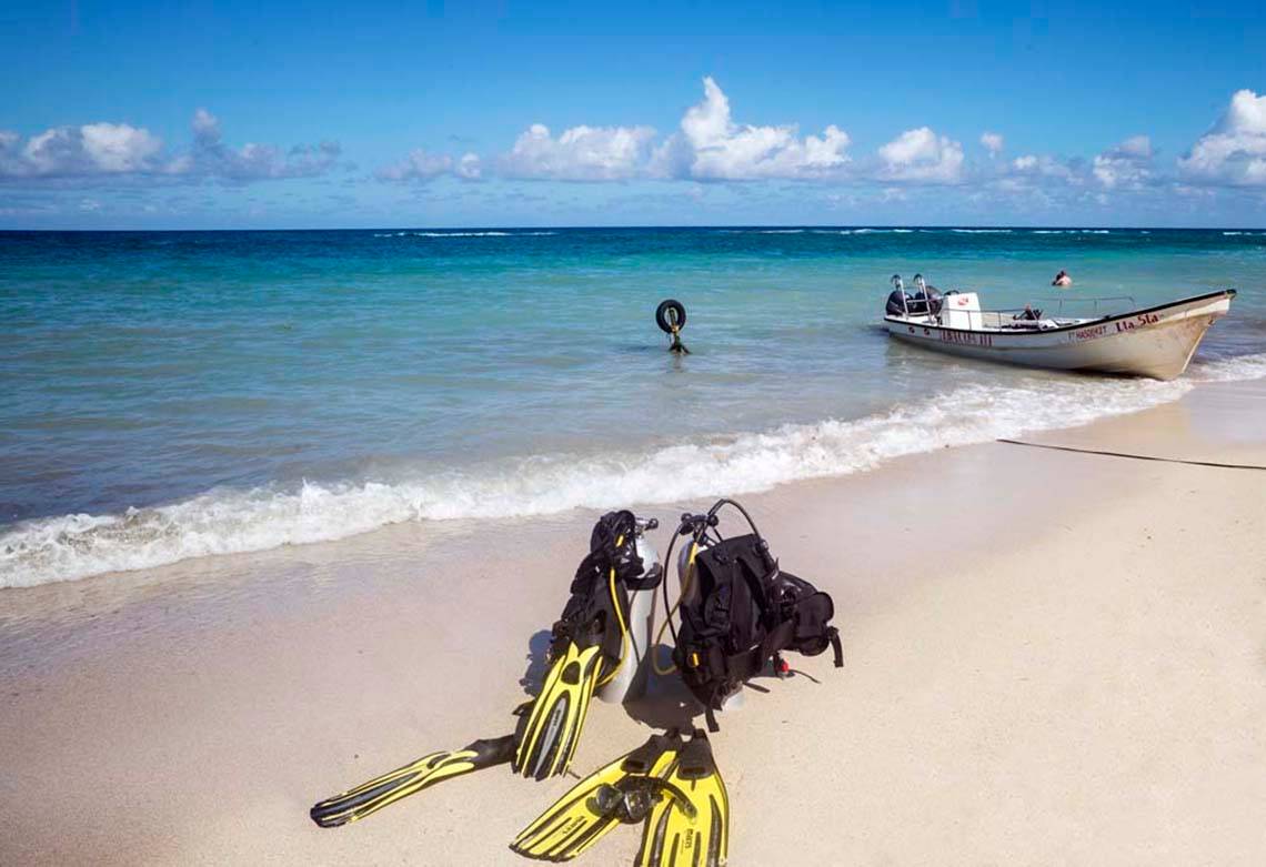 Strand mit Tauchausrüstung und einem Boot im Wasser am Memories Jibacoa Resort