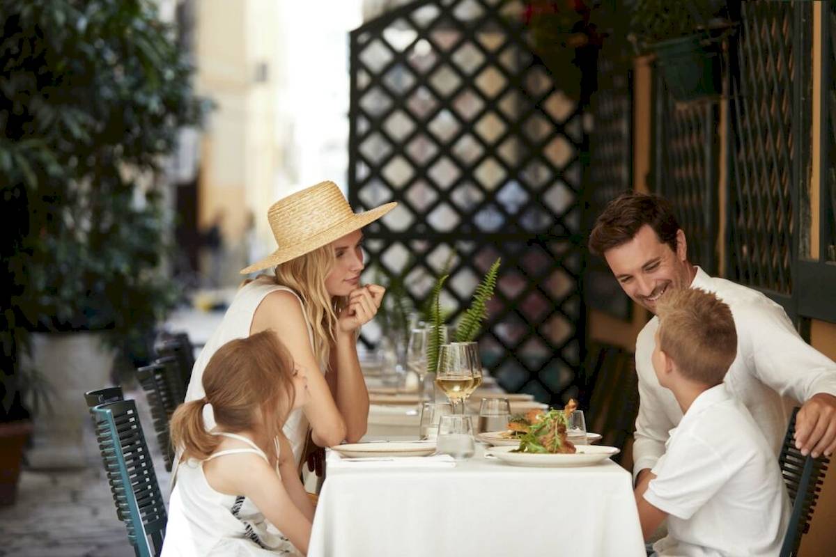 Eine Familie sitzt im Freien in einem Restaurant von Ikos Odisia.