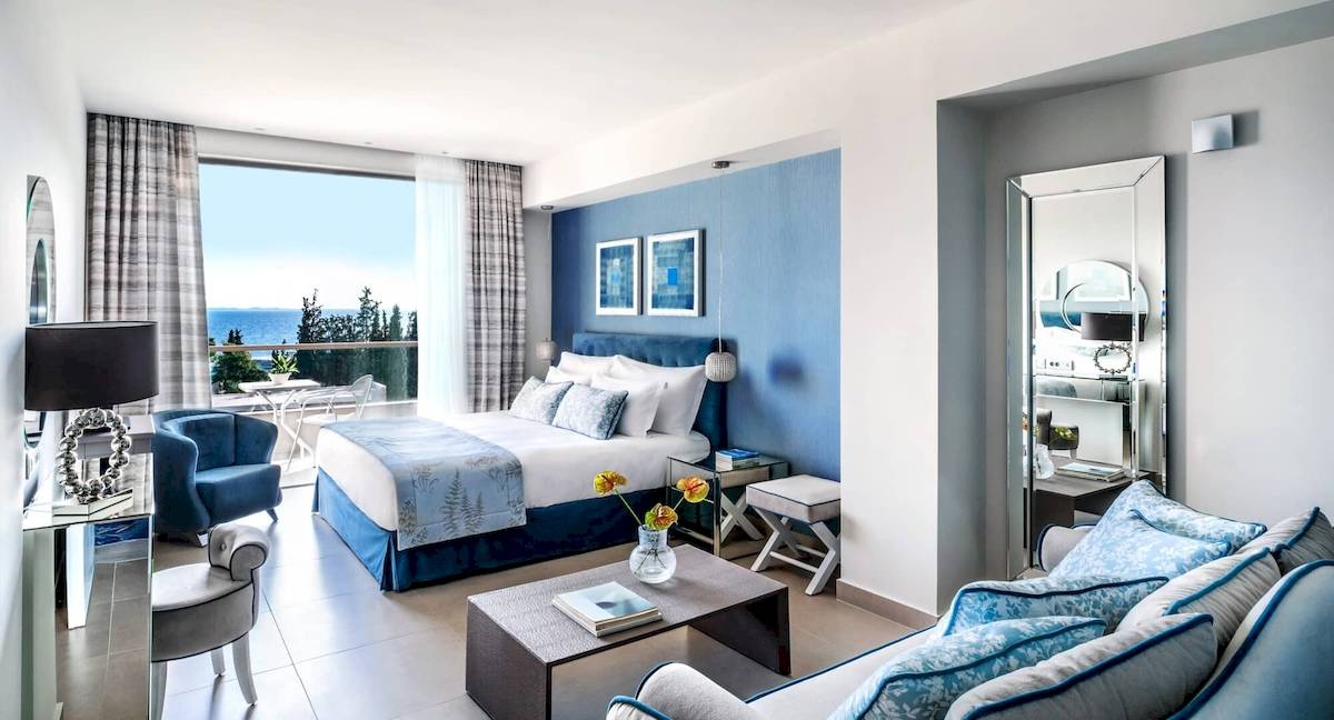 Innenansicht eines Hotelzimmers im Ikos Olivia Hotel mit Blick auf das Meer.