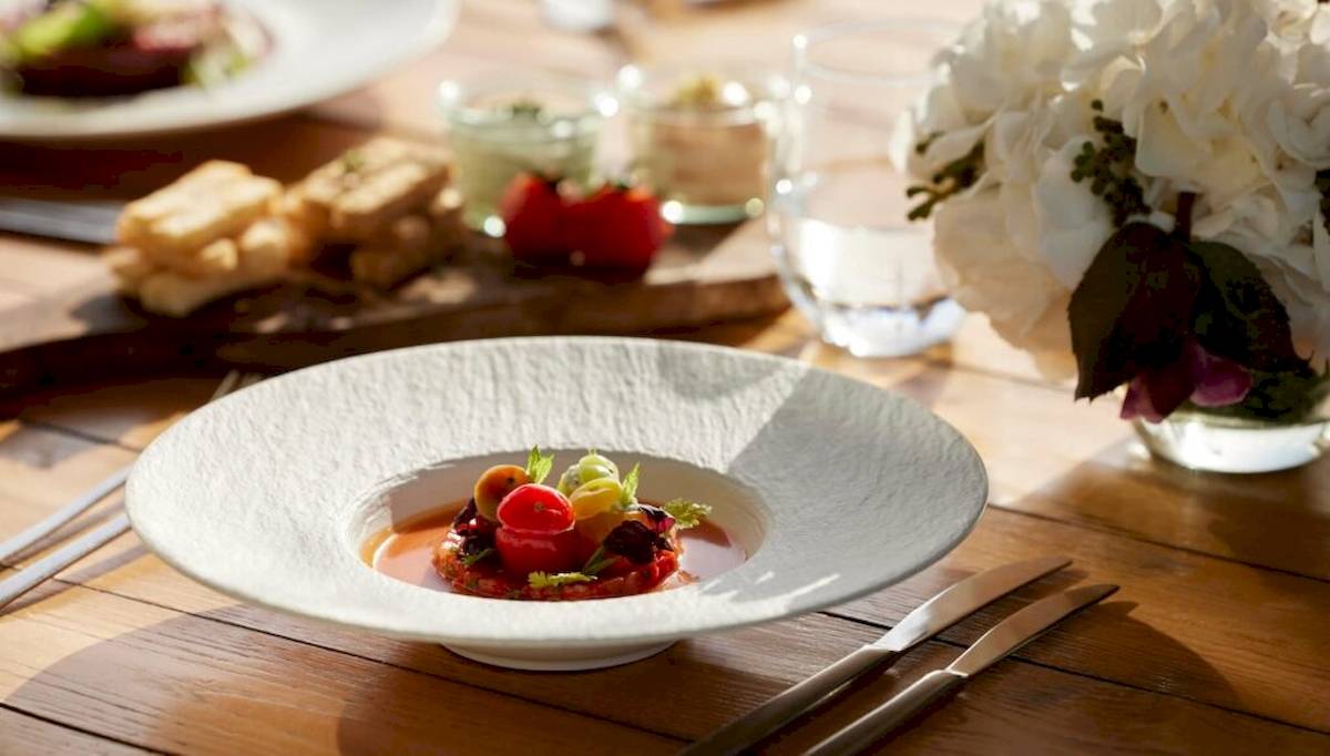 Gedecker Tisch mit Gericht im Ikos Olivia Hotel