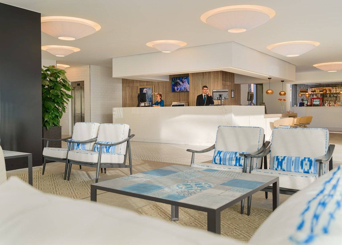 Lobby des H10 Casa del Mar Hotels mit Rezeption, Sitzbereichen und Bar.