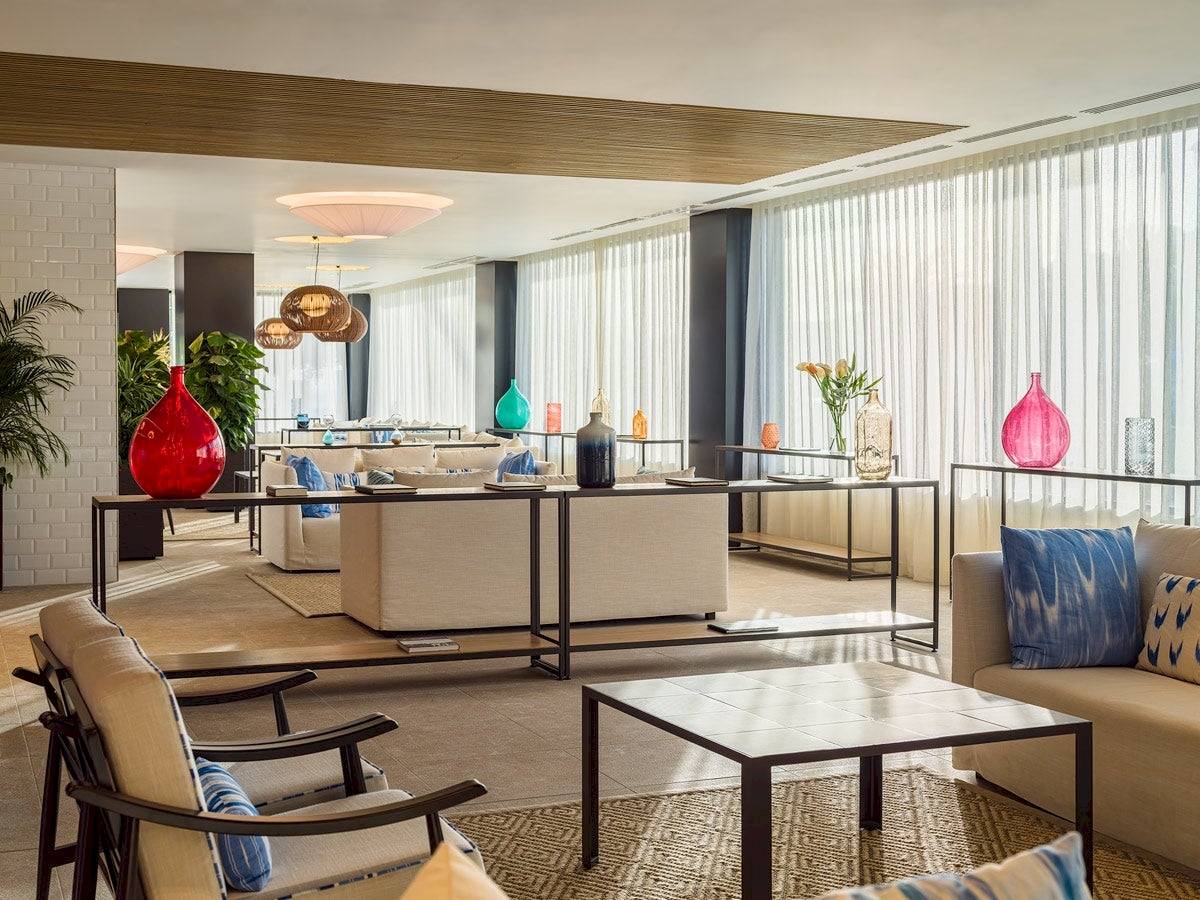 Lobby des H10 Casa del Mar Hotels mit Sofas, Tischen und farbigen Vasen.