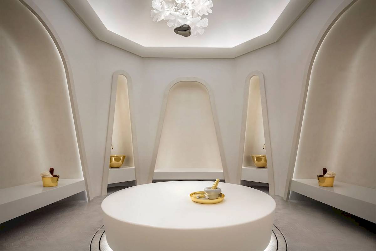 Wellnessbereich im Atlantis The Royal Hotel mit einem zentralen runden Tisch und goldenen Schalen.