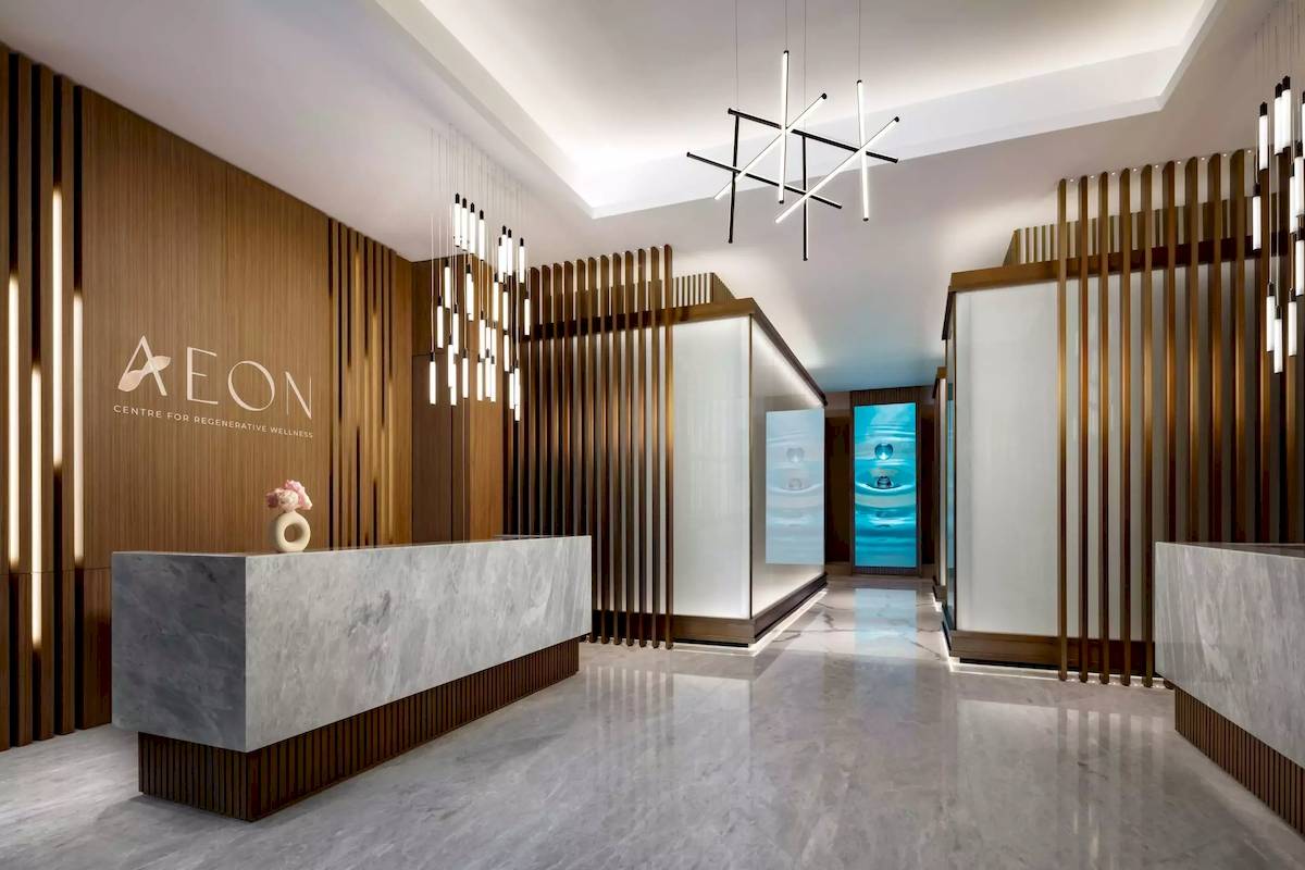 Empfang des Aeon Centre für Regenerative Wellness mit Marmortheke und Holzwänden.